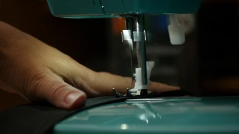 A female hand pushes material through a sewing machine Stock Footage 112186211