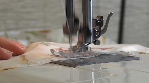A female hand pushes material through a sewing machine Stock Footage 124356912