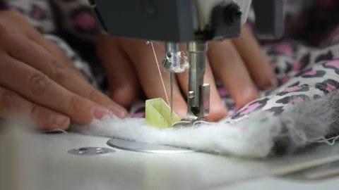 A female hand pushes material through a sewing machine Vídeos de archivo 241719262