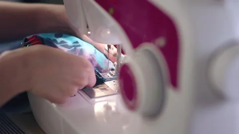 A female hand pushes material through a sewing machine. Stock Footage 269816151