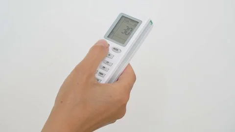 Female hand pushing temperature button on air conditioner remote control Stock Footage 76717009