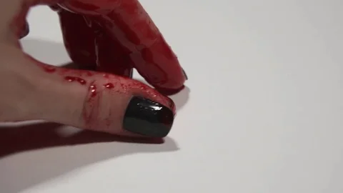 Female hand puts a wedding ring covered in blood on a white surface. Stock Footage 82900467