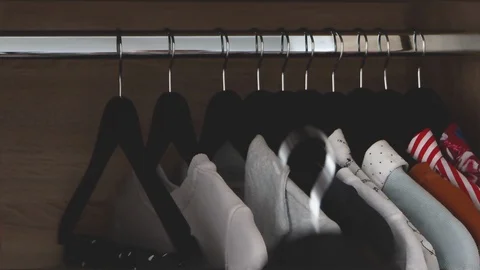 Female hand putting away their clothes in closet Stock Footage