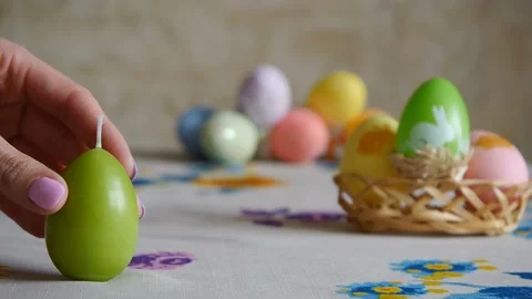 Female hand putting on the table three easter candles. Green, orange and yellow Stock Footage 106146765