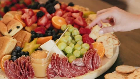 Female Hand Reaching into massive spread of fruits and breakfast foods Stock Footage 212132192