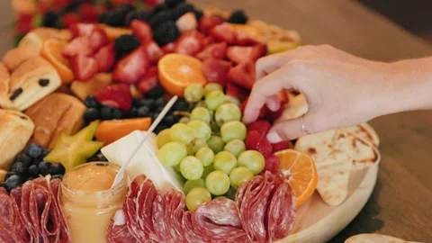 Female Hand Reaching into massive spread of fruits and breakfast foods Slow Mo Stock Footage 212143639