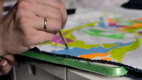 Female hand with a ring draws a brush and paints on denim. Stock Footage 105963857
