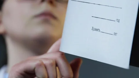 Female hand rotation folder document closeup. Girl looking catalog slow motion. Stock Footage 123115654
