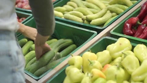Female hand selects cucumbers in the vegetable department of the supermarket Stock Footage 94076694