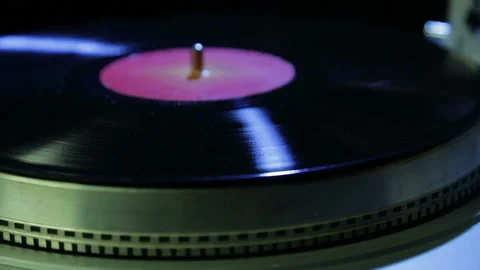 Female hand sets a turntable needle on a vinyl record in disco light Stock Footage 103294740