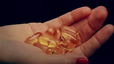 Female hand show pills with cod liver oil omega 3 gel capsules medicine drug Stock Footage 47719335