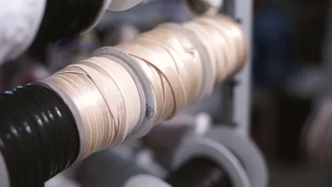 Female hand slowly pull beige webbing from the spool in the rack Stock Footage 72102097