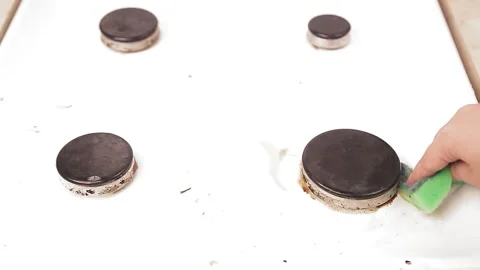 A female hand sponge with detergent washes a gas stove from grease and dirt. Stock Footage 132936387