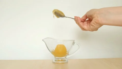 Female hand with a spoon and a jar of honey on a white background. Stock Footage 131662896