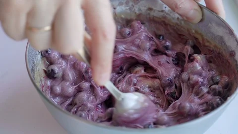 Female hand with spoon preparing dough for blueberry pie in stainless steel bowl Stock Footage 106881815