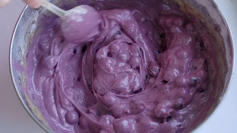 Female hand with spoon preparing dough for blueberry pie in stainless steel bowl Stock Footage 106881901