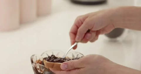 Female hand spreading jam on bread slice 스톡 동영상 276359413