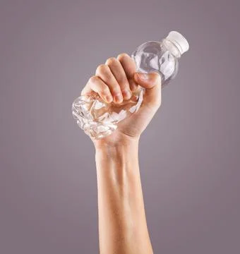 Female hand squeezes an empty plastic bottle Foto stock