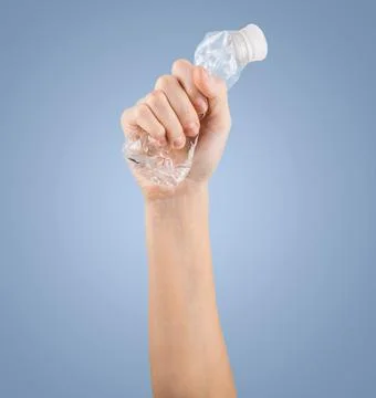 Female hand squeezes an empty plastic bottle Foto stock