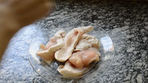 Female hand squeezing lemon over raw chicken breast Stock Footage 114776424