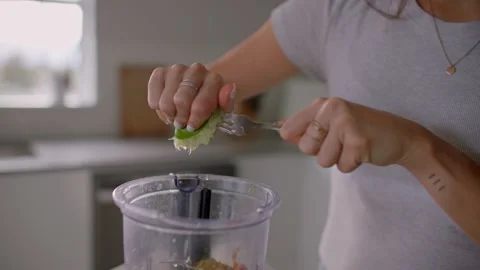 Female hand squeezing lime in kitchen, cooking food 库存影片 220753603