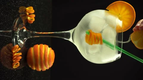 Female hand squeezing an orange into gin cocktail, 4k vertical video, close up Stock Footage 155787228