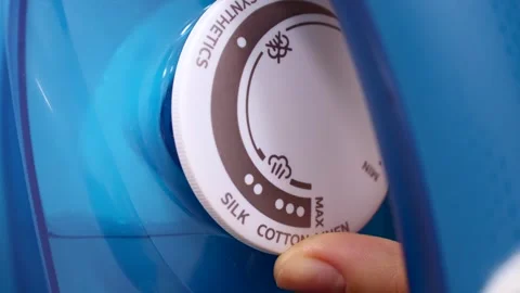 Female hand switch the control wheel with different ironing modes on the iron Stock Footage 264092917
