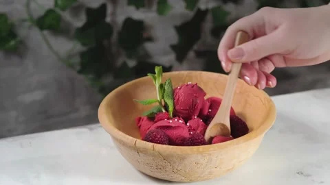 Female hand takes with a spoon raspberry sorbet from the bowl Stock Footage 171375984