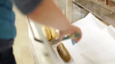 Female hand taking a loaf of bread tongs adds to the package at the supermarket Stock Footage 62751596