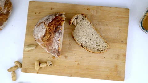 Female hand taking a slice of bread from a cutting board 스톡 동영상 144868383