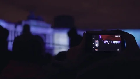 Female hand taking video of 3D mapping light show on a mobile phone. Stock Footage 82238774