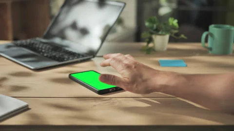 Female hand tapping on smart phone mobile green screen Stock Footage 311937574