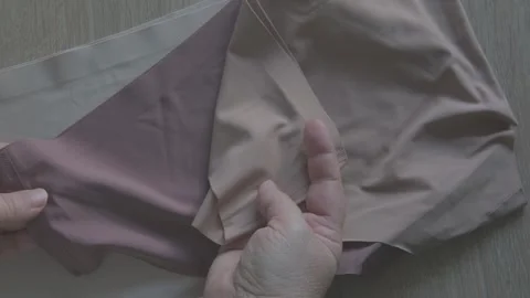 Female hand testing elasticity seamless panties, Woman choosing delicate un.. Stock Footage 327875864