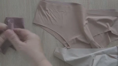 Female hand testing elasticity seamless panties, Woman choosing delicate un.. Stock Footage 327876001
