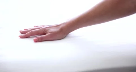 Female hand testing hardness of white orthopedic mattress 스톡 동영상 220469423