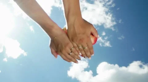 Female hand throw up apples on a background of blue sky. Slowmotion Video stock 67707900