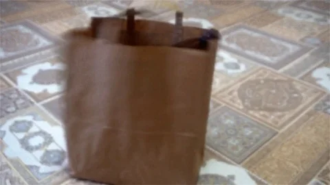 Female hand throwing empty plastic bottles in a paper bag Video stock 83292777