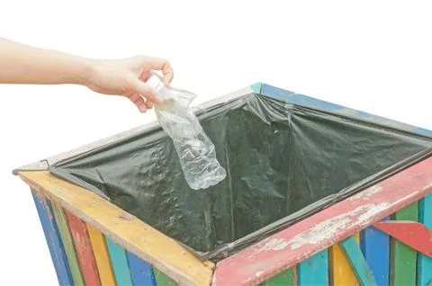 Female hand throwing empty plastic bottle into the trash, with white backgrou Stock Photos