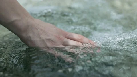 Female hand touching fresh clear water in mountain stream. Slow motion 4K shot Stock Footage 232804021