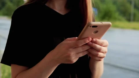 Female hand touching smartphone, scrolling feed on a street Stock Footage 157008082