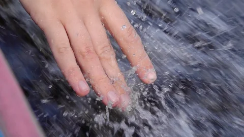 Female Hand Touching Splashes of Foaming Water with Fingers while Floating on Stock Footage 102653867