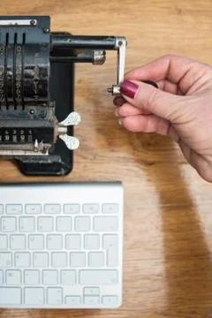 Female hand turninghandle of an adding machine Stock Photos