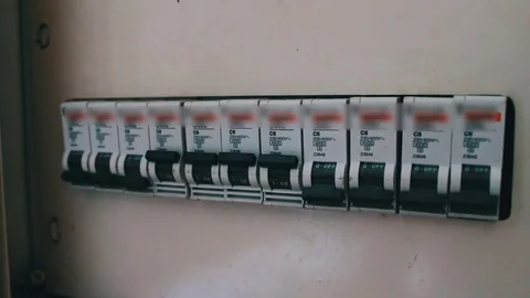 The female hand turns on and off the toggle switch on the electrical panel that Stock Footage
