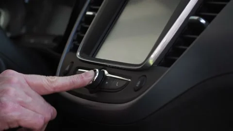 Female hand turns on and turns up the volume to car radio Stock Footage 143373583