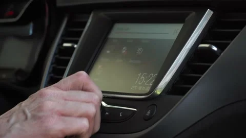 Female hand turns on and turns up the volume to car radio with screen on Stock Footage 143459769