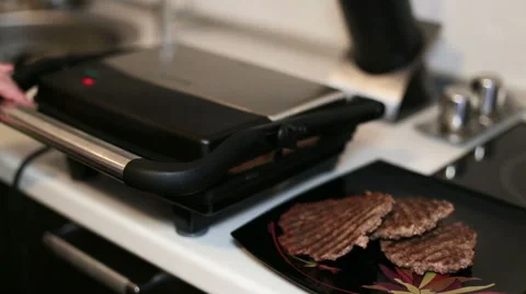 Female hand turns a light bread on an electric grill. Close-up Stock Footage 60574705