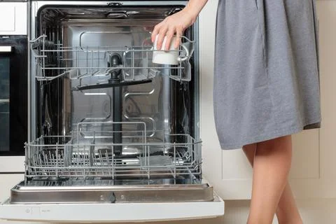 Female hand unloading dishwasher with tableware. Kitchen appliances, lifestyl Foto stock