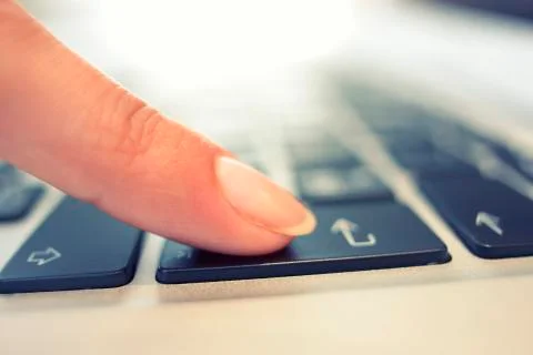 Female hand using computer keyboard, enter button Stock Photos
