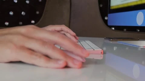 Female hand using computer mouse next to keyboard in close-up side view, desktop Stock Footage 333767824