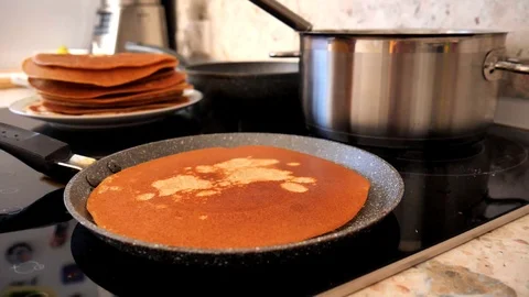 A female hand using a green silicone spatula puts butter on a traditional Rus 库存影片 118665998
